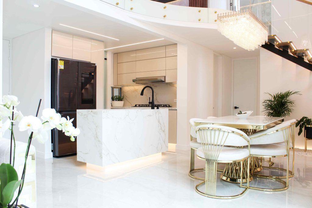 Cocina abierta con isla, orquídeas y mobiliario contemporáneo, ejemplo de diseño de interiores de apartamentos en Bogotá